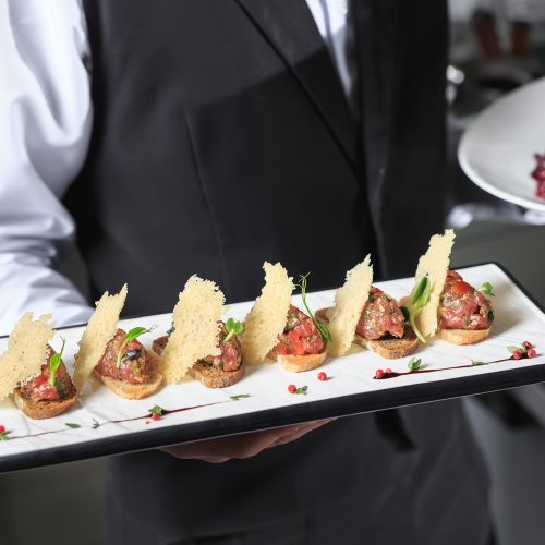 The waiter with the ready prepared dishes in the restaurant kitchen